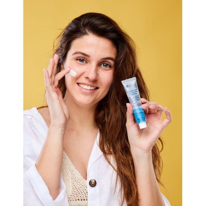 Ragazza applica sul viso la crema solare antiage con SPF30