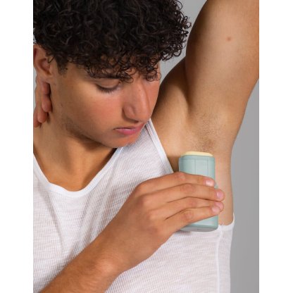 Ragazzo con applicatore Kiima e deodorante solido esotico fruttato