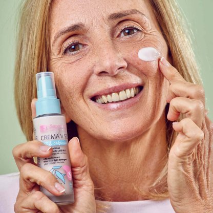 Donna matura applica la crema viso collagene