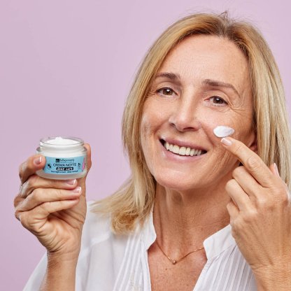 Donna matura applica crema viso ai peptidi
